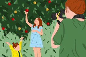 mother photographing daughters apple picking