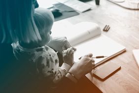 woman holding child in lap while doing work