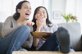 Women laughing and watching a comedy together