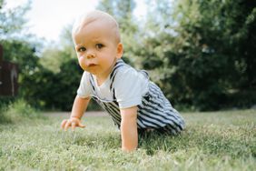 Baby boy crawling in grass