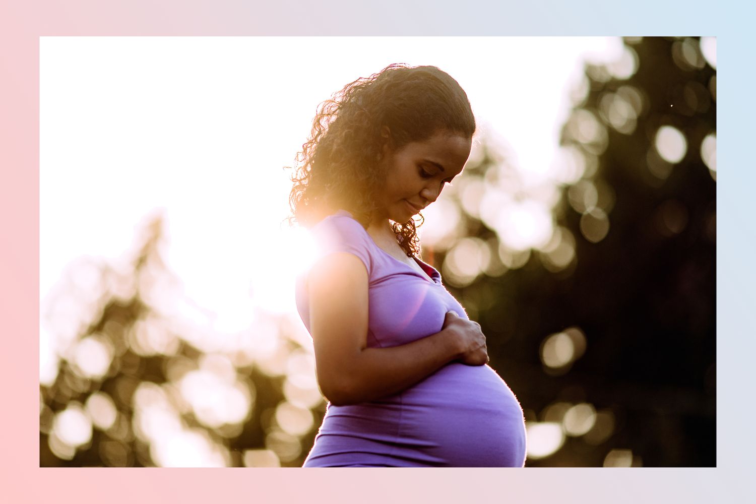 Pregnant Black woman standing outside