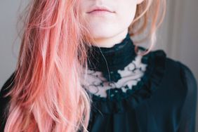 An image of a teenage girl with pink hair.