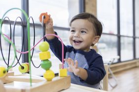 happy toddler playing with a toy