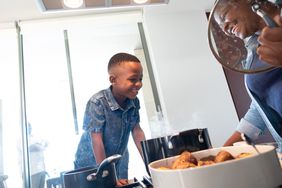 Senior woman cooking food with her grandson