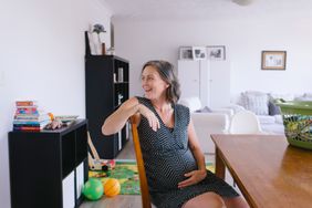 Mature pregnant woman sitting at a table 