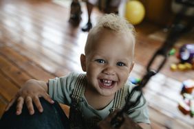 Smiling toddler boy with curly blonde hair