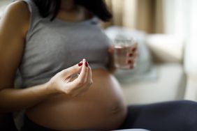 pregnant person taking a pill