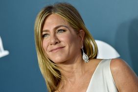 Jennifer Aniston smiling with blue background