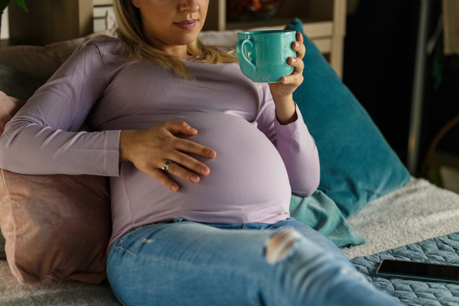 pregnant person feeling their belly