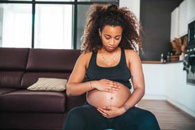 pregnant woman looking at her belly