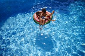 Mother and son floating in swim ring in a pool