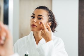 Person applying retinol cream to face