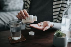 close up of person pouring out vitamins