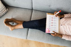 woman holding a menstrual cycle calendar