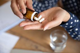 close up of a person's hand pouring pills