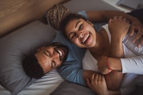 young couple on bed indoors at home