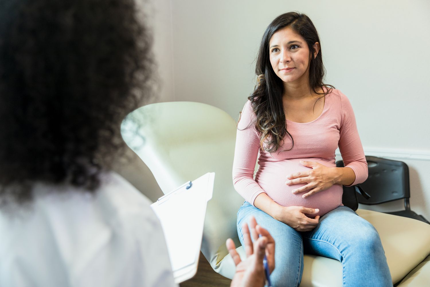 Pregnant women touches stomach at OB-GYN doctor's office