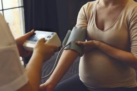 Pregnant person getting blood pressure measurement