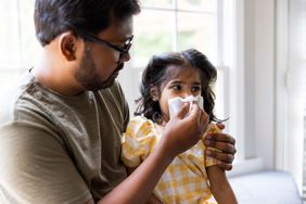 father helping her daughter blow her nose