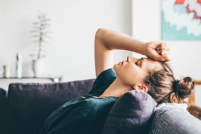 Woman not feeling well laying on couch 