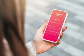 hand holding a mobile phone with a period calendar app