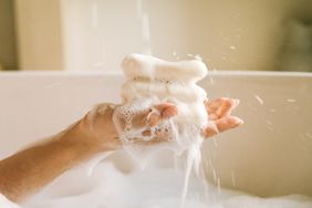 person holding soap in the bath