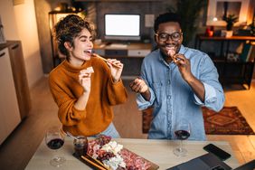 couple enjoying wine and snack at home