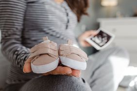 pregnant person holding baby shoes and ultrasound