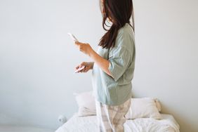 person holding phone and menstrual pad