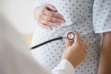 Doctor examining pregnant person