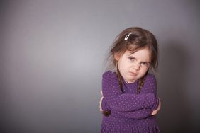 Uncomfortable toddler with arms crossed over their chest