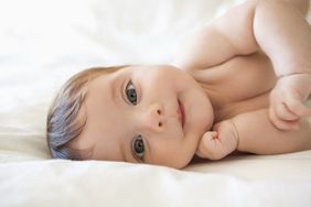 Baby girl laying on bed