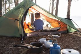 Young boy sitting alone in tent