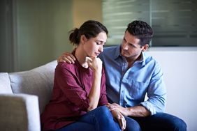 A couple talking while sitting on a couch