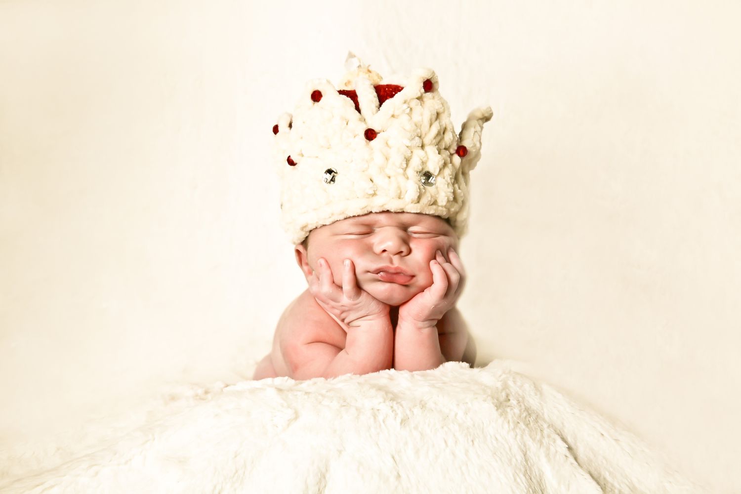 Newborn baby posed with a crocheted crown