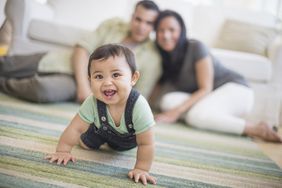 Happy baby boy crawling on the floor