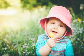 baby girl holding a flower