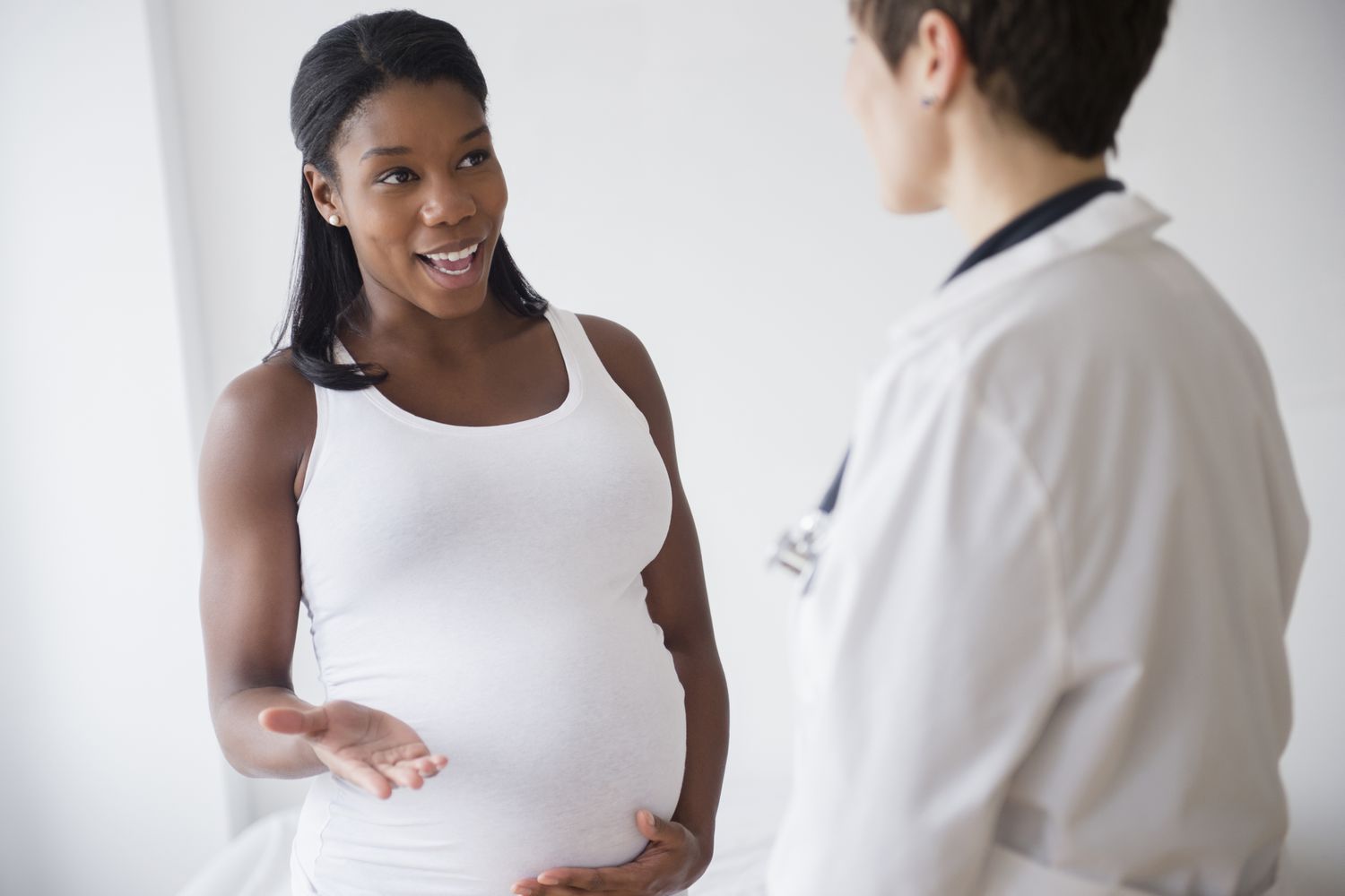 Pregnant woman discussing issues with her doctor.