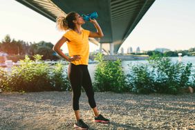 woman drinking water after exercise