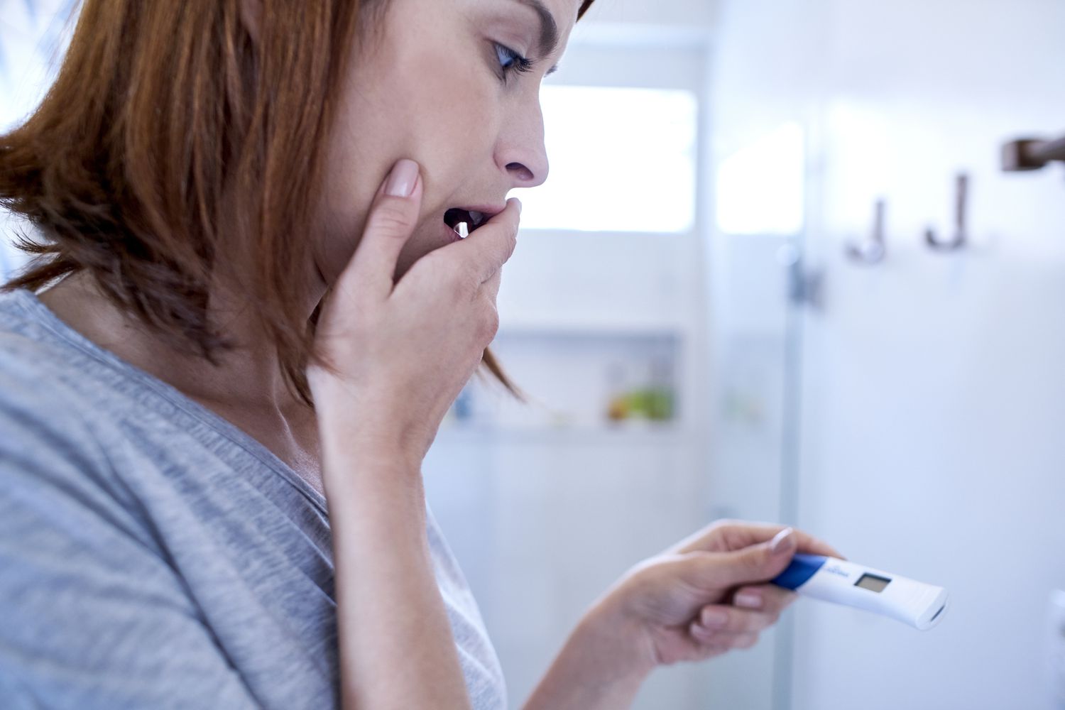 Scared woman looking at pregnancy test