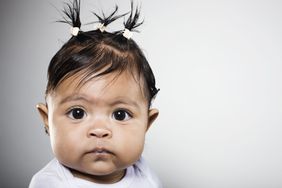 Baby girl with short dark hair pulled back in three hair clips