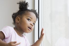 cute Black baby girl looking out of the window