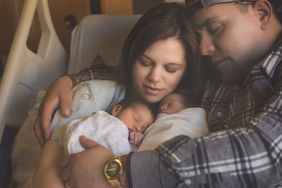 Newborn Fraternal Twins Snuggle Up Together With Parents in Hospital Bed