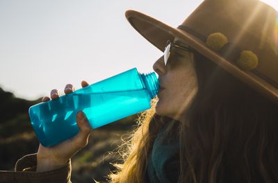 Woman on a hiking trip drinking from water bottle