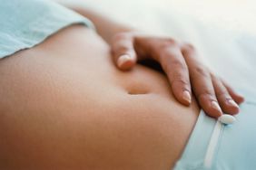 close up of a woman touching her stomach