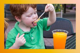 Young boy uses a spoon to drink a slushie-type drink.