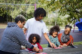 Two moms play with their children in the park 