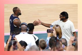 LeBron James of Team United States high fives his son and NBA player Bronny James on the basketball court.