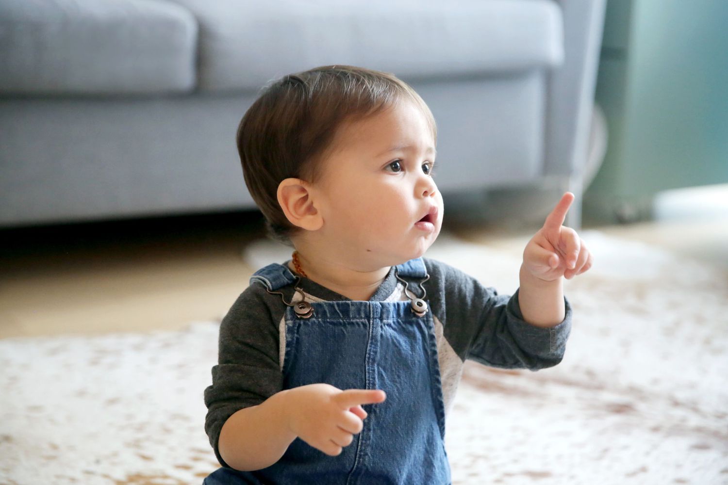 Baby boy in overalls pointing. 