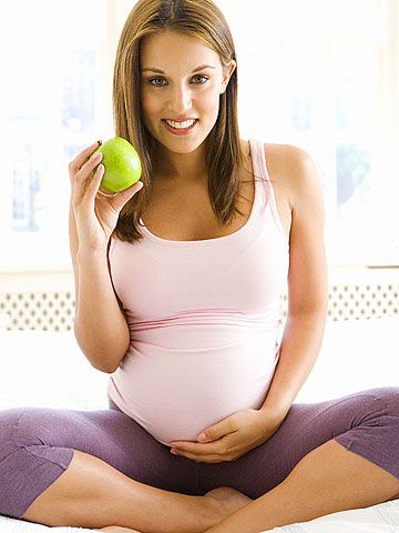 pregnant woman eating apple